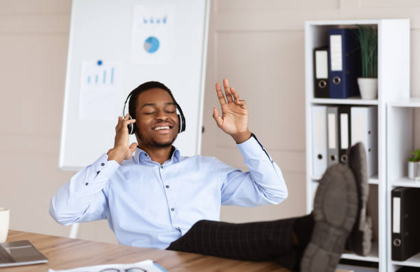 istock Joyful black manager listening to music in his office 1299556889