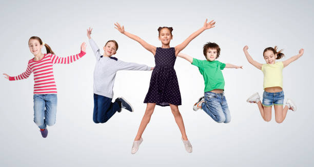 istock Cheerful Boys And Girls Jumping On Gray Studio Background, Collage 1299557103