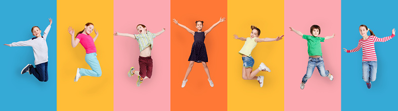 Carefree Children Jumping Posing Together Wearing Casual Clothes On Colorful Studio Backgrounds. Collage With Happy Preteen Boys And Girls Jump In A Row. Childhood Fashion Concept. Panorama