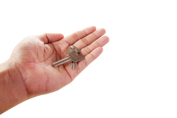 istock Human hand holding key to a dream house isolated 1299560403