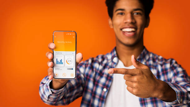 istock Black Guy Showing Phone With Physical Activity App, Orange Background 1299560690