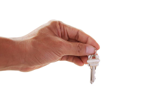 istock Human hand holding key to a dream house isolated 1299561385