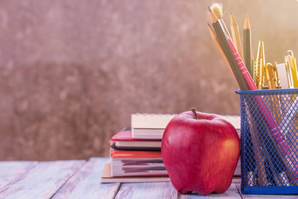 istock Back to school, Close up red apple,pencil and notebook or notepad with morning sunlight 1299561951