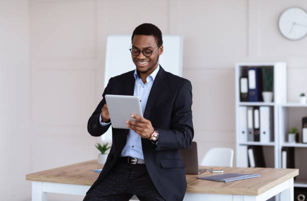 istock Joyful african american businessman using newest digital tablet 1299563623