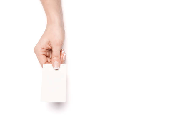 istock Female hand holding a blank business card over white background 1299566196