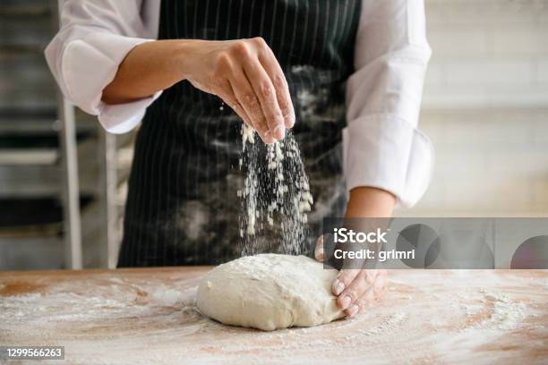 A Baker Dusting Flour On A Dough To Make Bread Stock Photo - Download Image Now - Bakery, Baker - Occupation, Bread
