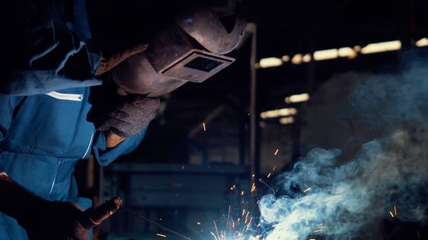 istock Skillful metal worker working with arc welding machine in factory 1299566302