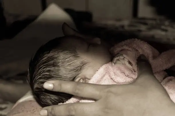 Photo of Beautiful Newborn baby boy photo laying in mother lap in prenatal hospital.