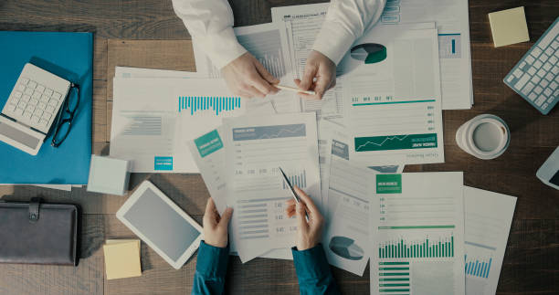 istock Business people checking financial charts together 1299568238