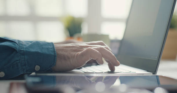 istock Man sitting at desk and working with a laptop 1299570525