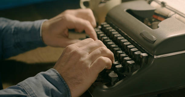 businessman typing on a vintage typewriter - writing typewriter 1950s style retro revival imagens e fotografias de stock