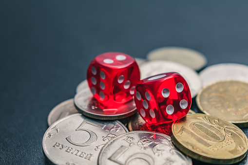 Red Dice are on different coins won at casino bets. Casino dice gambling