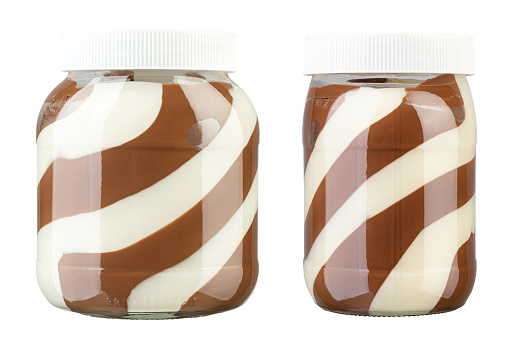 Open glass jar full of different colourful jelly candies on white wooden background