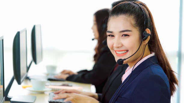 istock Business people wearing headset working in office 1299571957