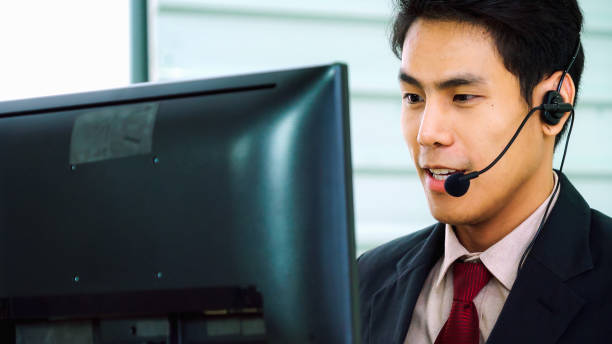 istock Business people wearing headset working in office 1299574017