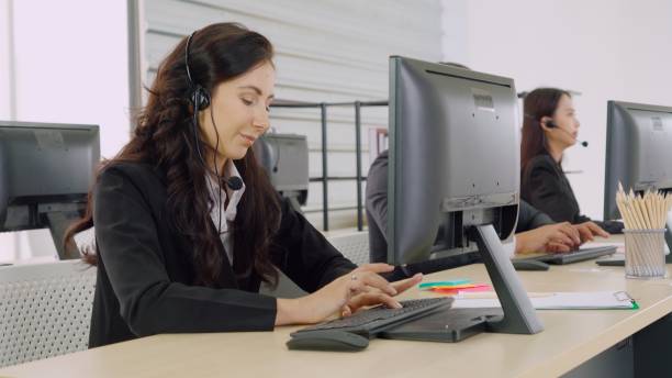 istock Business people wearing headset working in office 1299575240