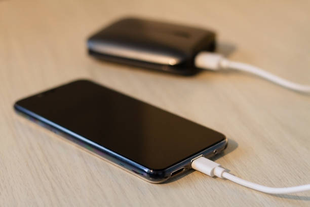 istock Charging your smartphone from a portable charger, close-up. 1299577198
