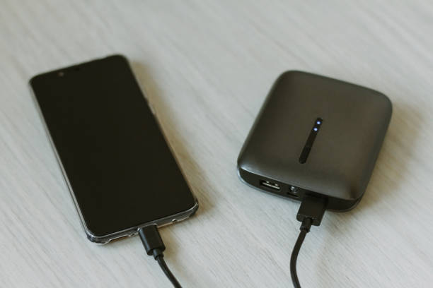istock Charging your smartphone from a portable charger, close-up. 1299577204