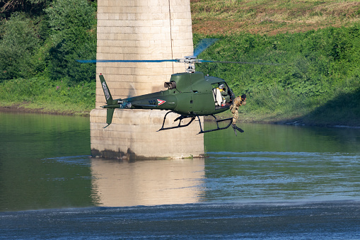 Szolnok / Hungary - August 20, 2019: Hungarian Air Force Airbus Helicopters Eurocopter AS350 H125M Ecureuil 102 military helicopter drops a military diver into tisza river