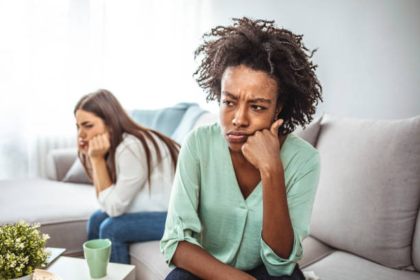 istock Two female friends sitting on sofa and arguing with each other. 1299580589