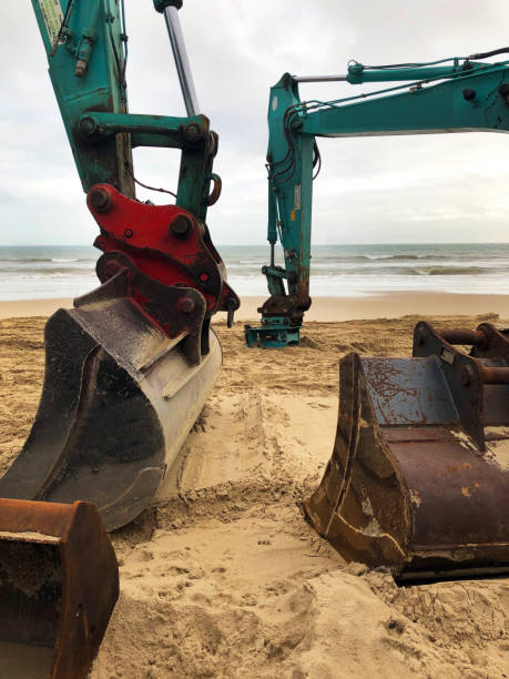 istock Digger buckets and plant in winter beach scene, Dorset , England 1299580868