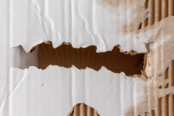 istock Narrow strip of torn hole in a cardboard box 1299584049