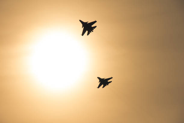 istock Two plane silhouettes in the sky against the bright sun 1299584519