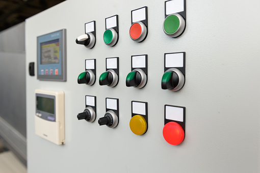 Control panel with push buttons on a factory metal plate.