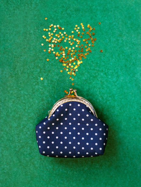 istock Confetti golden heart from purse on green background 1299586346