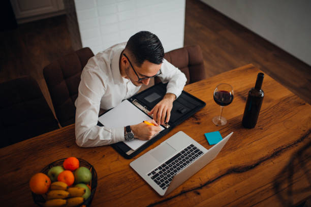 Work from home young businessman works from home in the evening and uses his laptop vollbart stock pictures, royalty-free photos & images