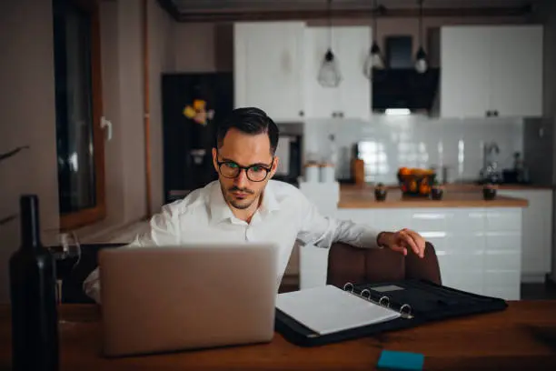 young businessman works from home in the evening and uses his laptop