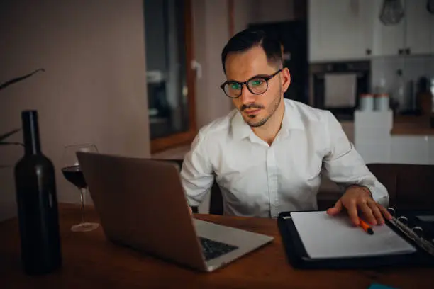 young businessman works from home in the evening and uses his laptop
