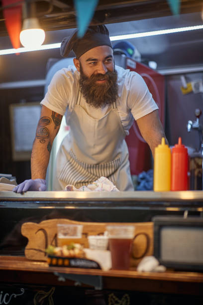 istock young hipster working in fast food service, wearing cook hat 1299590040