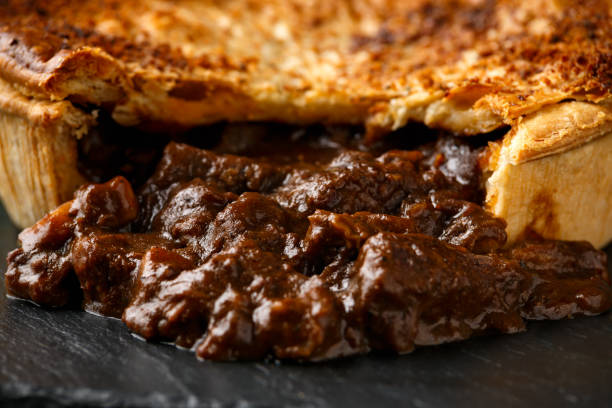 istock British beef steak pie with onion, wine gravy on rustic stone board 1299590121