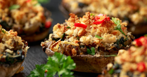 istock Stuffed mushrooms with spinach, bread crumbs and cheese on stone board 1299590344