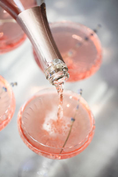 Glasses with cold pink champagne placed on table Glasses with cold pink champagne with lavender flowers placed on table crystal chalice stock pictures, royalty-free photos & images