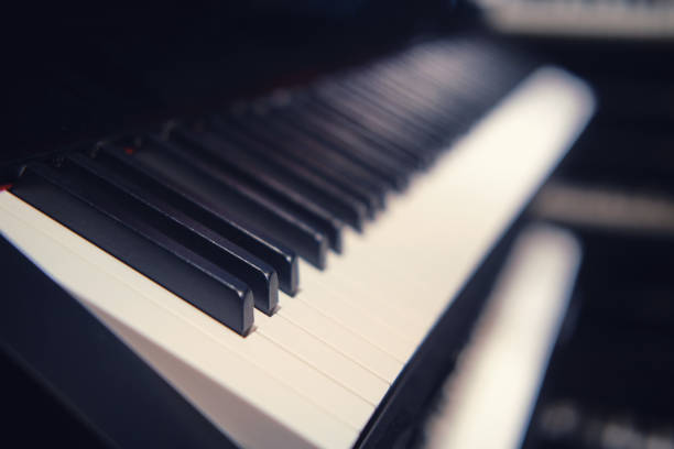 istock Black and white electronic synthesizer keys, new modern piano close-up 1299595352