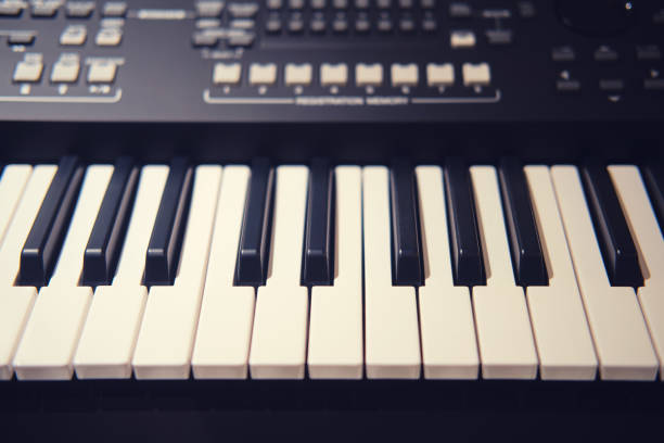istock Black synthesizer with white keys, modern electronic piano with sliders and buttons for recording music 1299595359