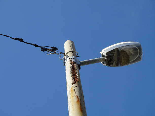 Street lamp rusted with damage to concrete power line lamp