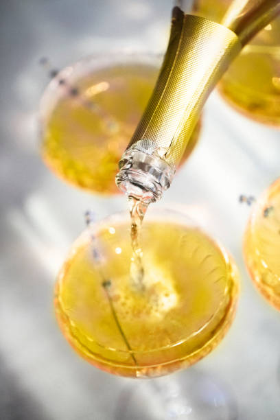 Glasses with cold champagne cocktail placed on table Glasses with cold illuminating yellow champagne cocktail with lavender flowers placed on table crystal chalice stock pictures, royalty-free photos & images