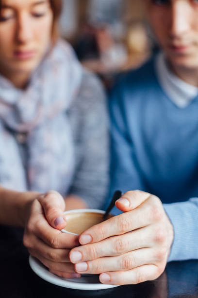 istock Two Hands Wrapped Around A Cup Of Coffee 1299596588