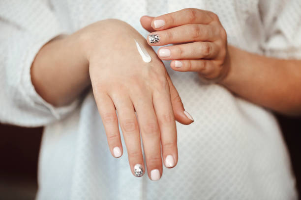 istock Crop woman applying cream on hands 1299596693