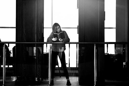 Monochrome shot of university student in casual clothes having good time in the library. Shot with DSLR camera canon 5dsr
