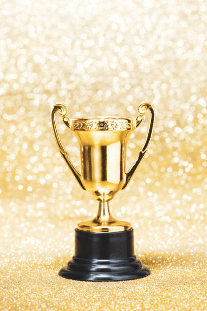 istock Golden trophy cup on shiny bokeh light background. 1299597878