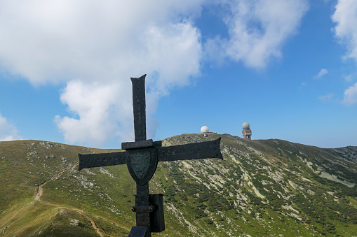 Speikkogel - A metal cross on top of Seespitze, with a distant view on Grosse Speikkogel, Austrian Alps.