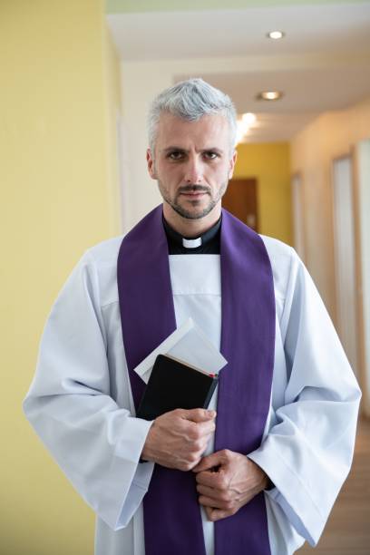 istock Catholic priest holding envelope with money during pastoral visit. 1299599801