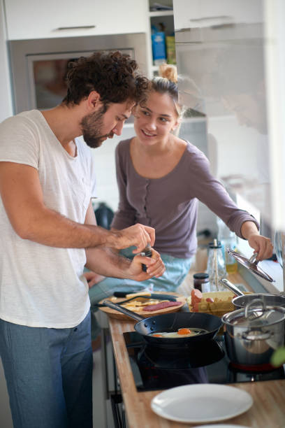 istock A young guy love preparing the food for his girlfriend. Cooking, home, kitchen, relationship 1299600286