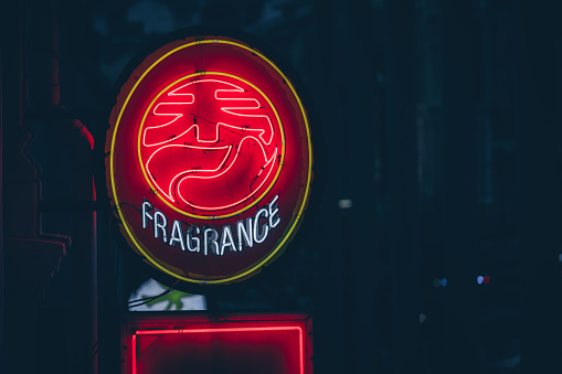 A neon chinese fragrance sign seen at night in the district of Chinatown in Singapore, Asia.