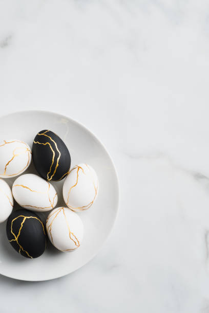 istock Stylish golden and black Easter eggs in plate on marble table. Flat lay, top view. Happy Easter vertical banner 1299603329