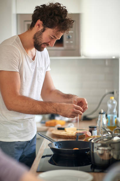 istock A young guy preparing a meal. Kitchen, food, home, cooking 1299603965